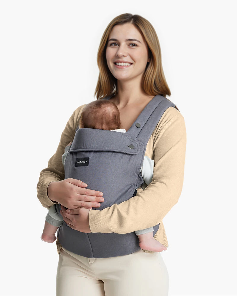 Momcozy PureHug baby carrier in gray, worn by a mother holding baby. Comfortable design for babywearing.